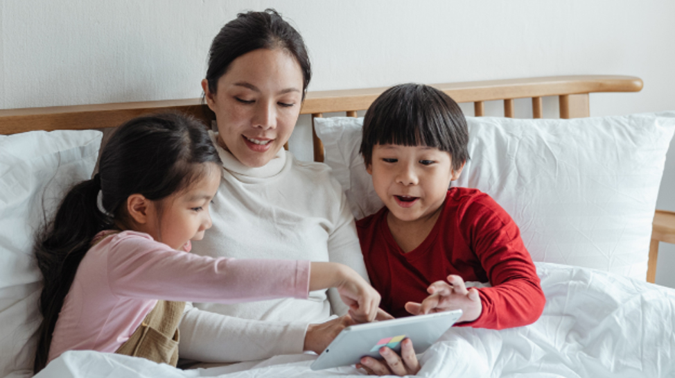 Mother and children playing with a tablet