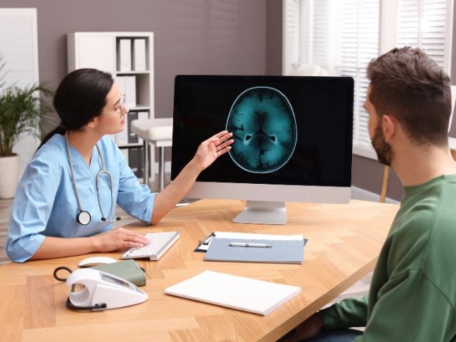 doctor showing a brain scan on a monitor
