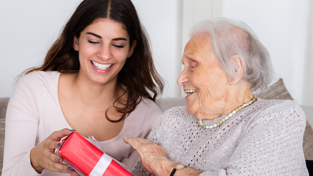 Elderly giving gift to young lady