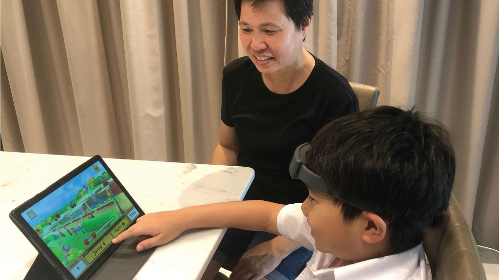 Neeuro partner Ching Kie supervises a child playing Cogo