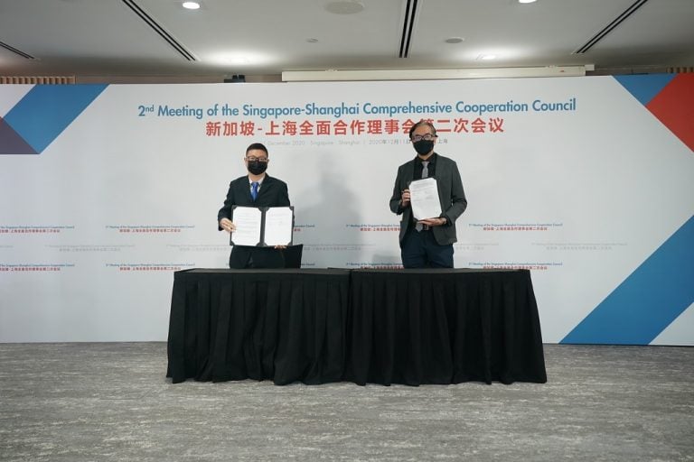 Dr. Alvin Chan and Dr. Feng Yi holding the signed MoU